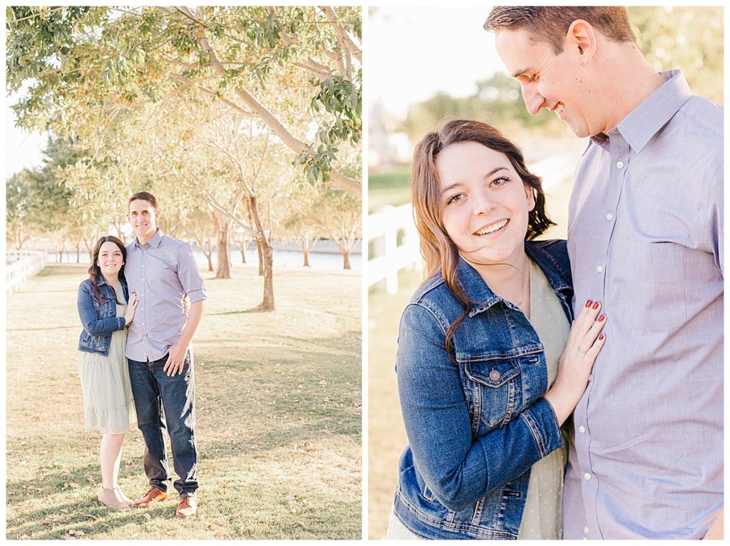 photo of a young couple standing in Morrison ranch under a balcony of green trees and nest to a white picket fence