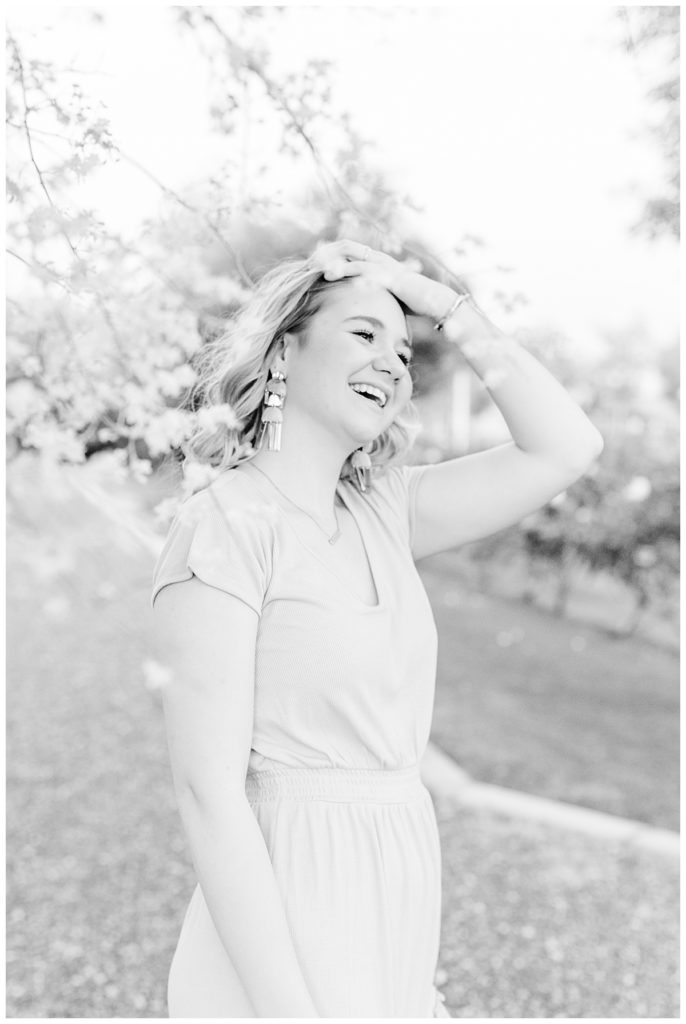 black and white photo of girl laughing and playing with her hair