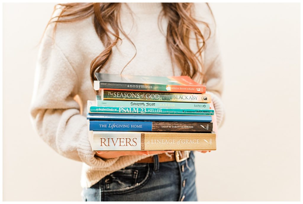 Girl holding a stack of books