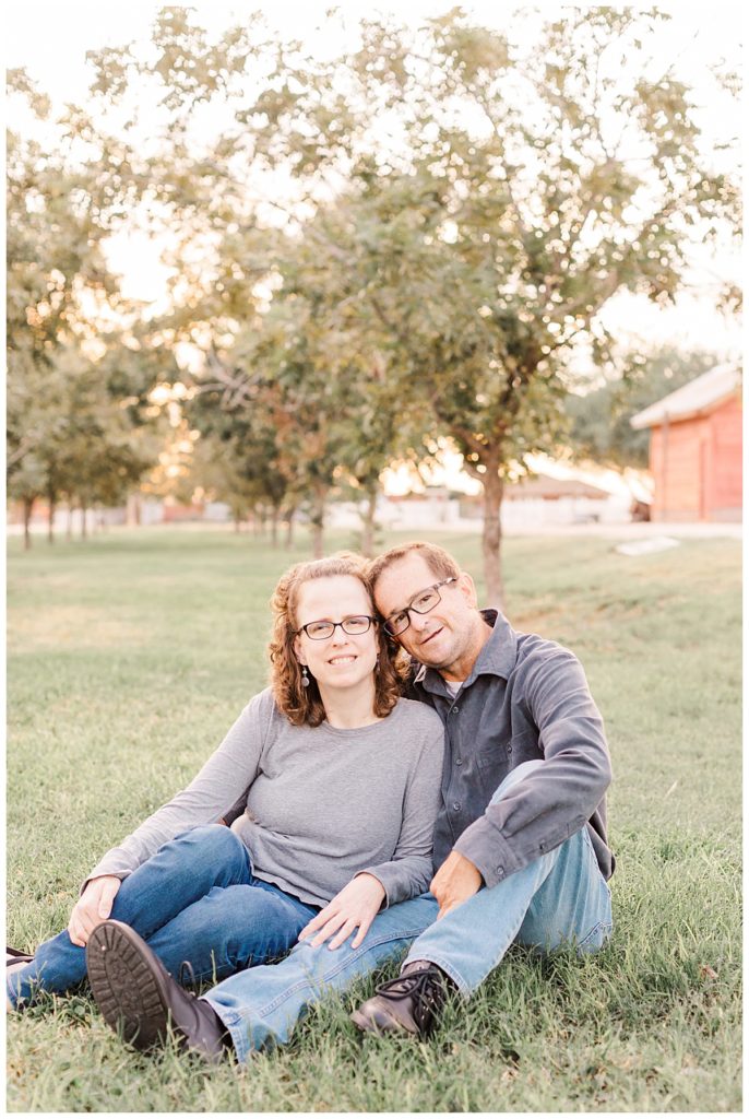 husband and white sitting and snuggling in the grass at Tumbleweed Park in Chandler Arizona