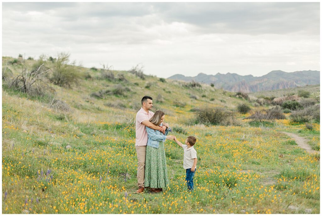 a little boy bring his mom a flower in a field of Spring Desert Wildflower | Bethie Grondin Photography