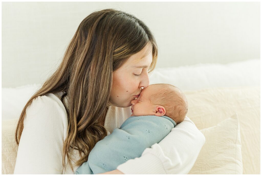 Gilbert, Arizona Newborn Photos | Mom kissing her Baby boy swaddled 