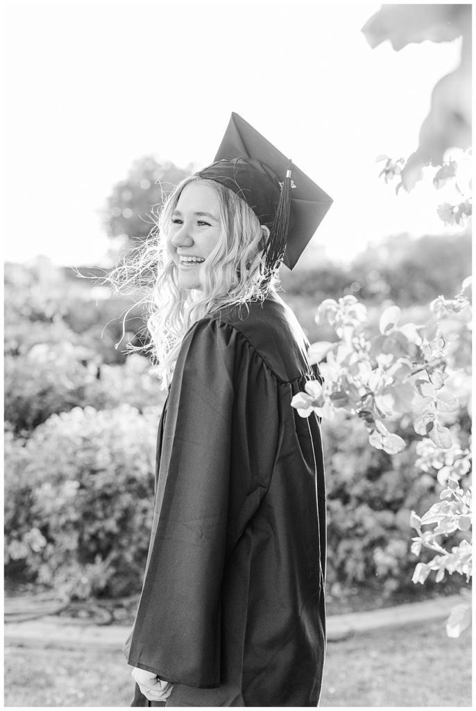 rose garden senior photos, black and white photo of girl wearing cap and gown laughing