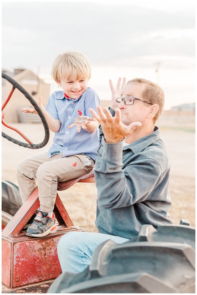 dad and little boy playing on a tractor at Jette's Family Photos at Tumbleweed Park in Gilbert Arizona