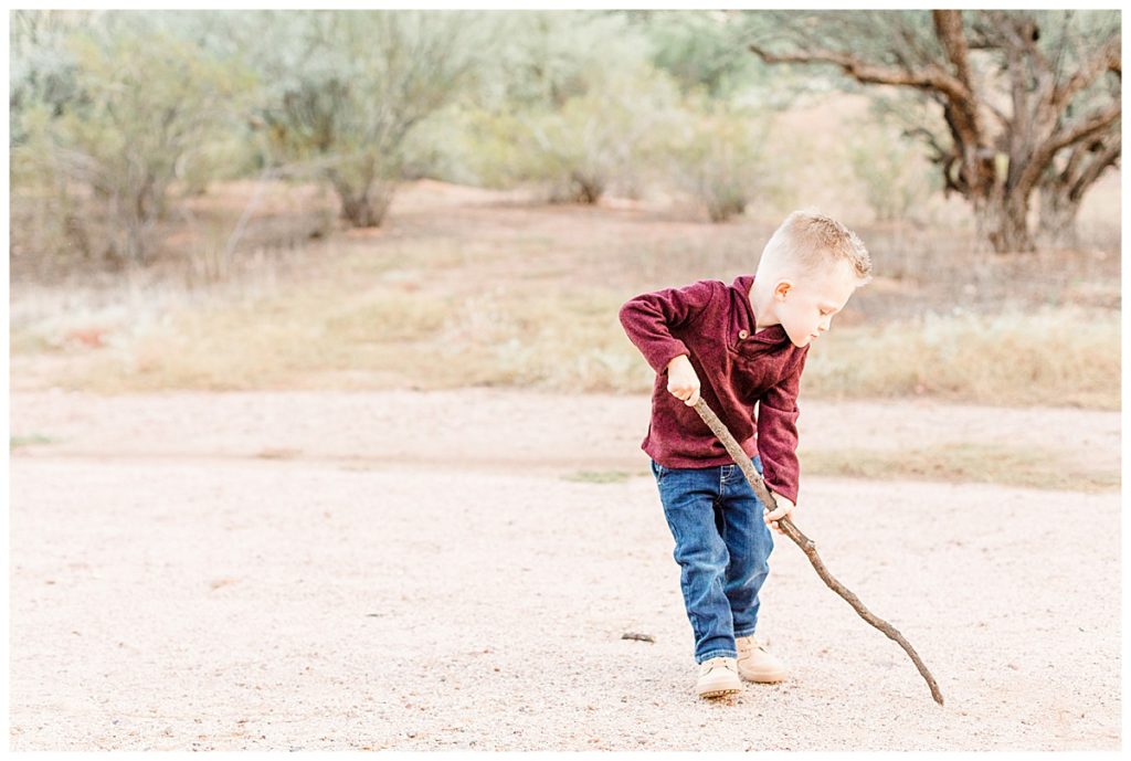 Little boy playing with a stick in the dirt at Coons Bluff