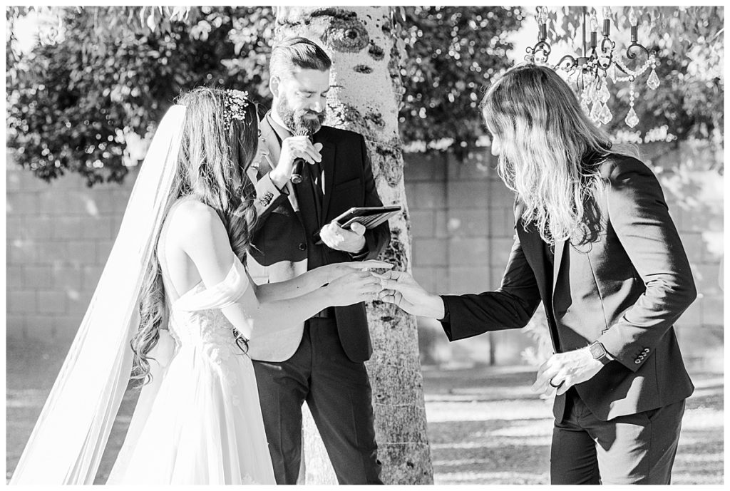 Black and white photo of Candice & Joel exchanging rings at Private Estate Scottsdale Wedding Ceremony