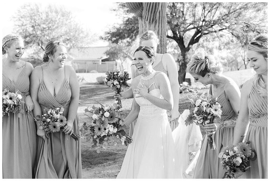 black and white photo of a bride laughing and walking with her bridesmaids at the Golf Club at Johnson Ranch Wedding