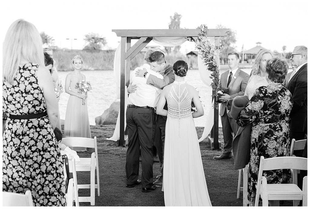 Black and white photo of a father giving away his daughter in marriage  at Natalie & Steven's Wedding Ceremony at the Golf Club at Johnson Ranch Wedding | Gilbert, Arizona